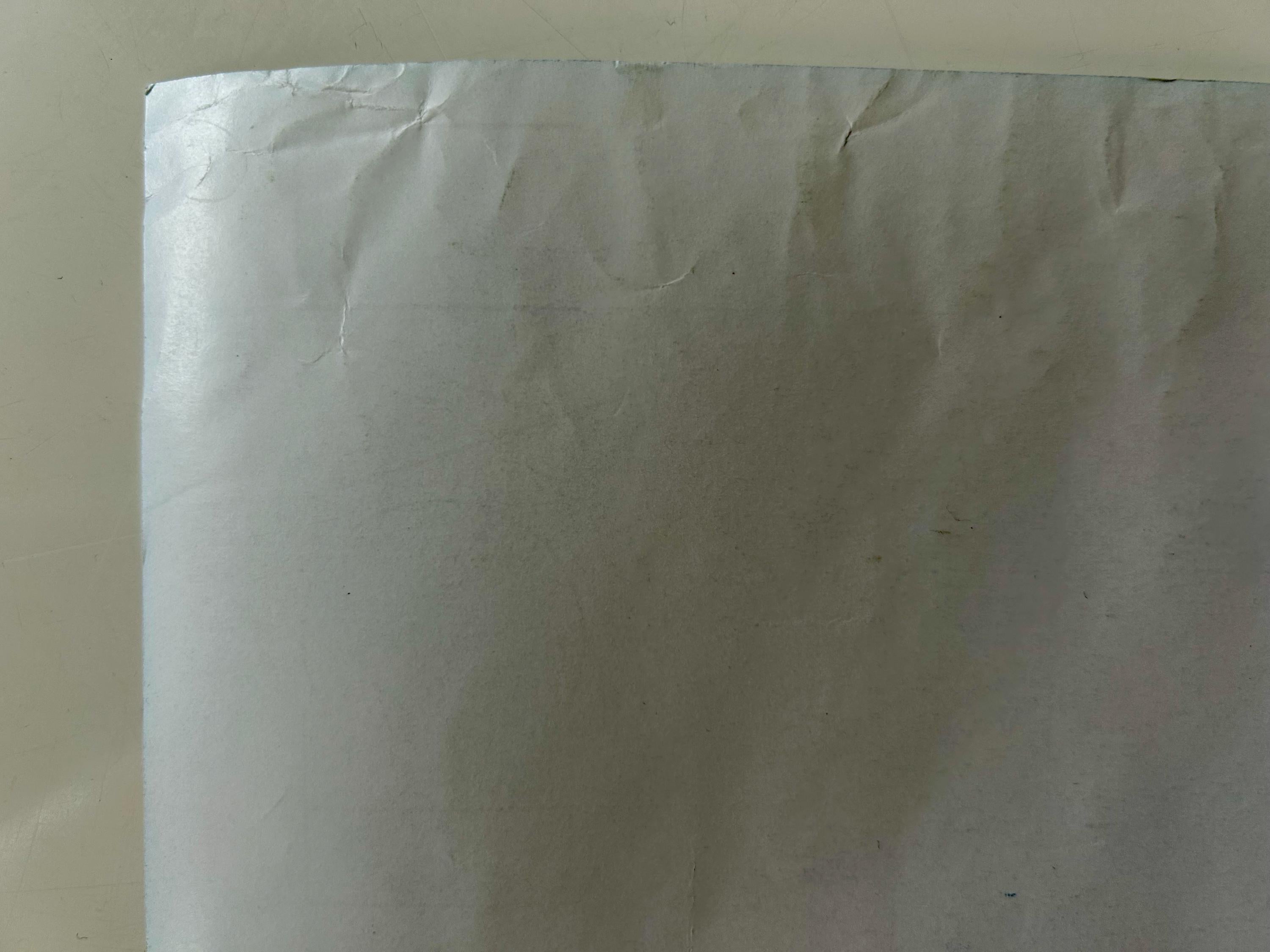 Close-up of a white sheet with visible texture and folds on a beige background