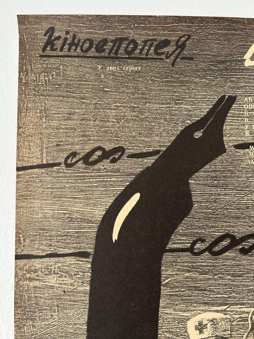 Black silhouette of a stylized ink pen on a textured brown background 