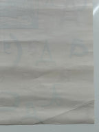 Close-up of a textured beige paper with a brand logo.