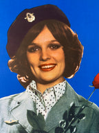 Close-up of a person wearing a black hat and polka dot shirt against a blue background