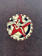 Decorative emblem with a red star and text on a dark background