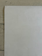 Plain white sheet of paper on a textured wooden surface