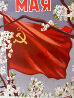 Red flag with hammer and sickle symbol, cherry blossoms, and 'MAY' text on a gray background