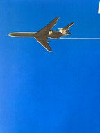 Metallic airplane model against a clear blue sky