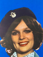 Close-up of a person wearing a cap with a blue background