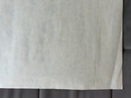 Close-up of a textured gray fabric with a subtle pattern on a dark background
