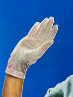 White glove on a person's hand against a blue background