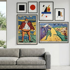 Colorful posters on a wall above a gray sofa