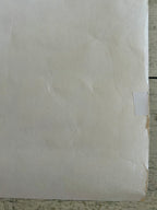 Close-up of a textured beige surface with a small square cutout.