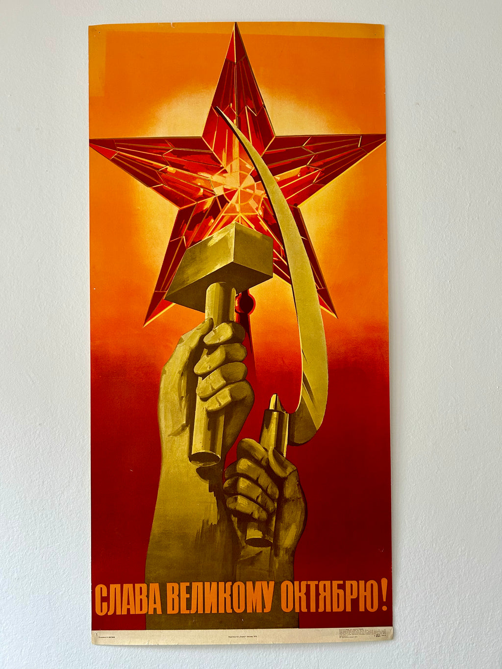 Vintage-style poster with a hand holding a hammer and sickle against a star, on an orange and red background.