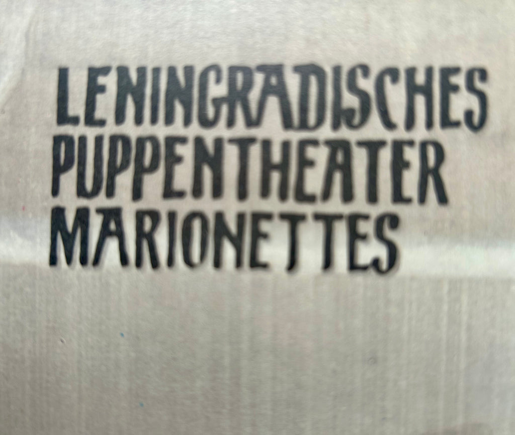 Text 'LENINGRADISCHES PUPPENTHEATER MARIONETTES' on a textured background