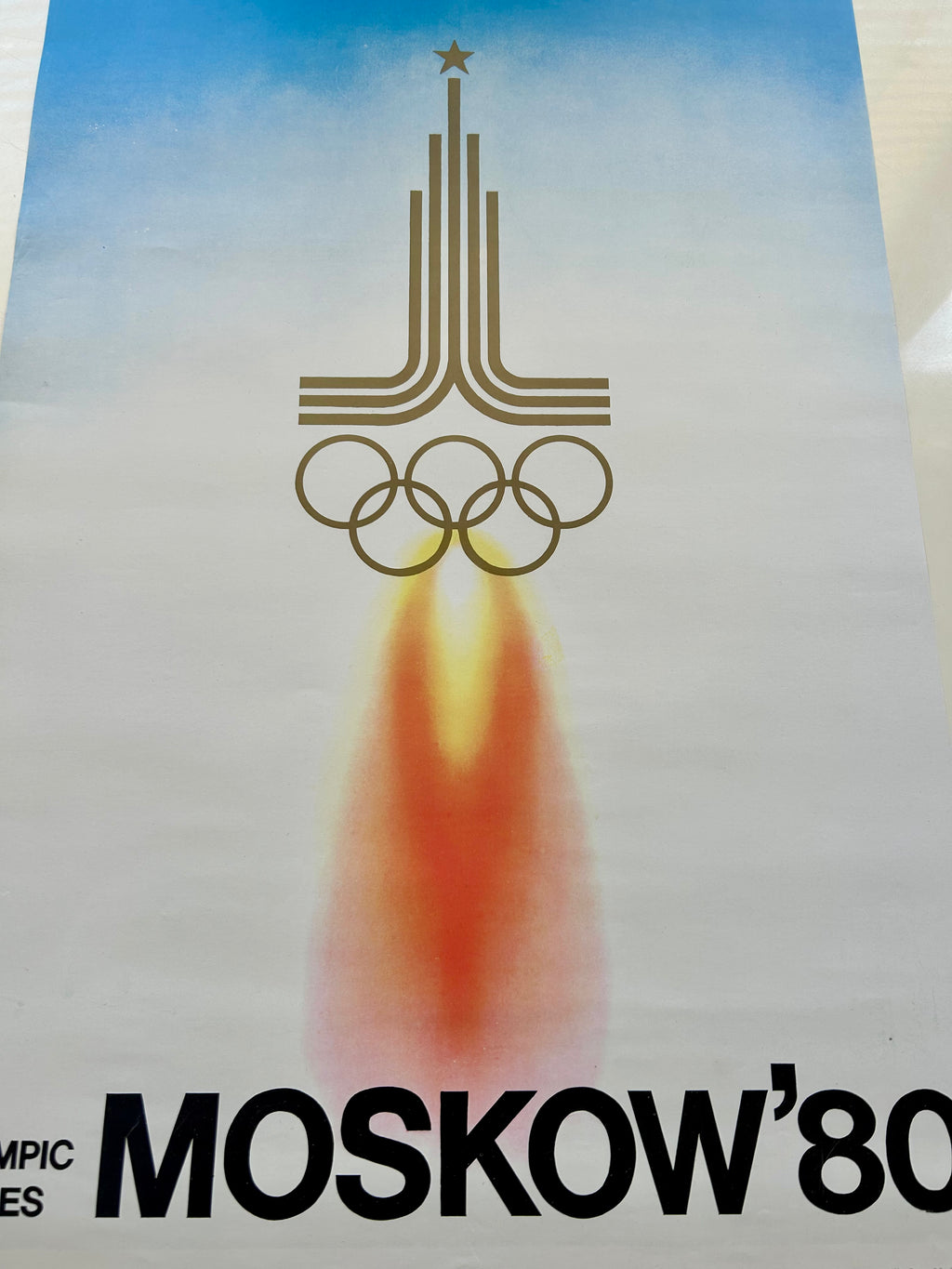 a fragment of  poster of the 1980 Moscow Olympics with a rocket and Olympic rings design.