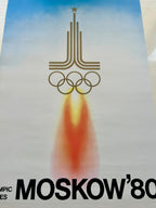 a fragment of  poster of the 1980 Moscow Olympics with a rocket and Olympic rings design.