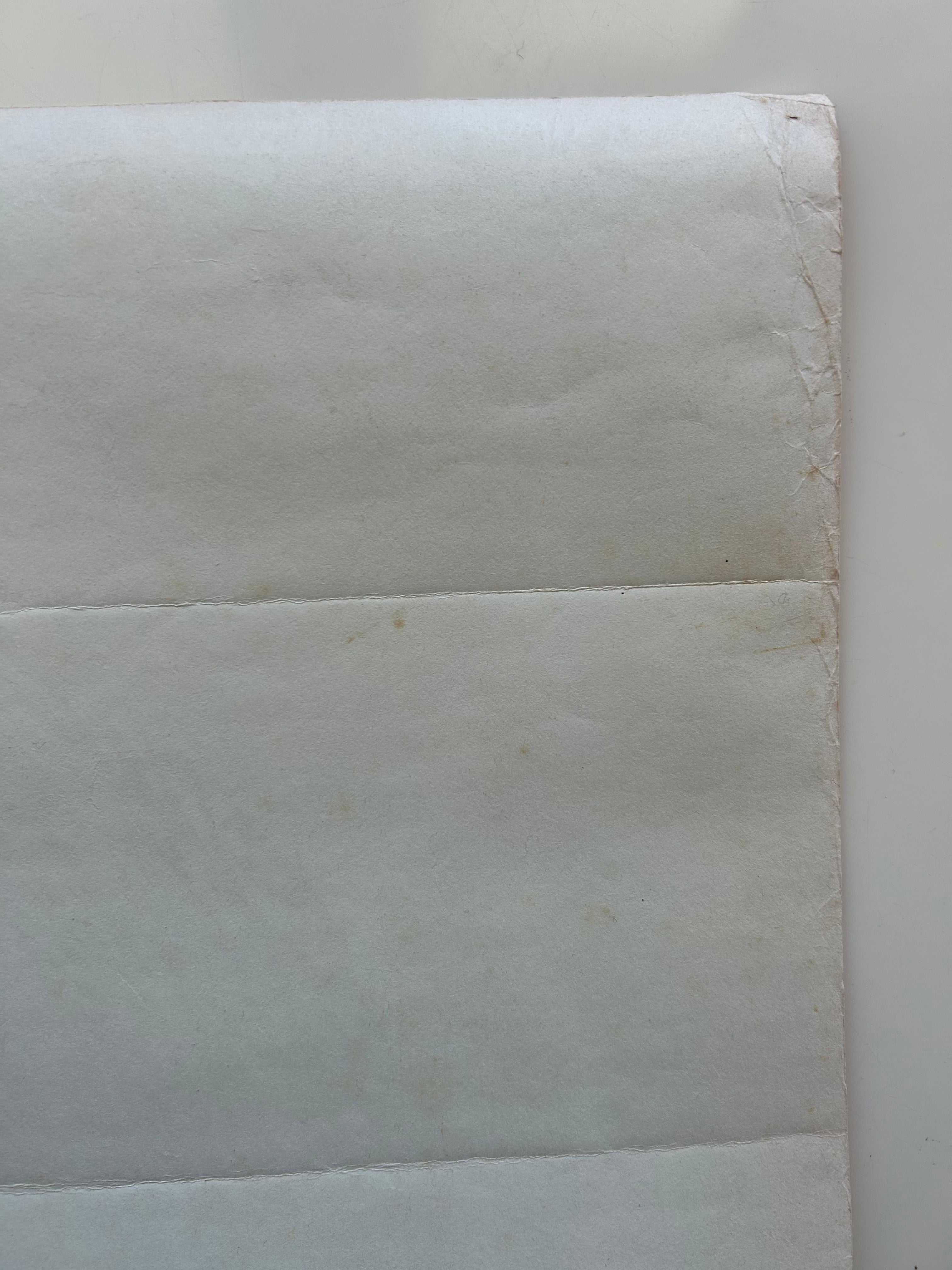 Close-up of a textured white paper with a slight brown discoloration.