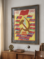 Framed Soviet-style poster with a rocket,  hammer and sickle symbol on a wooden desk.