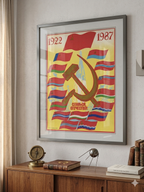 Framed poster with a  rocket, hammer and sickle symbol on a wooden sideboard.