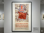 Vintage poster with a red flag and floral design on a gray wall.