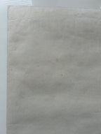 Sheet of beige paper with a small brown spot on a white background