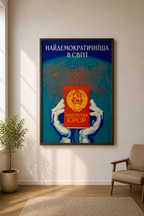 Framed poster with a world map and USSR Constitution a wall in a room with a plant and chair. 