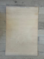 Beige paper sheet on a wooden surface with visible text