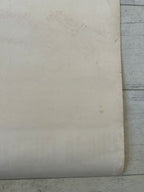 Close-up of a textured white surface with a wooden floor in the background