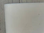 Close-up of a white cylindrical object on a textured surface