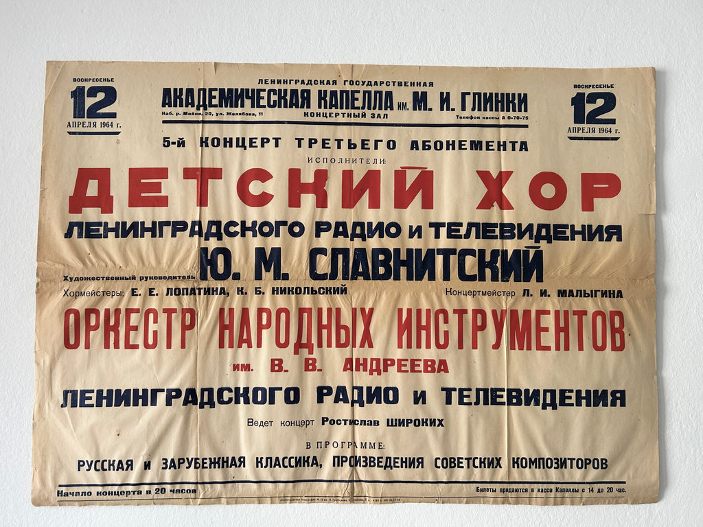 A vintage Russian concert poster for a children's chorus and orchestra performance, printed on aged beige paper with red and black text, photographed against a white wall.