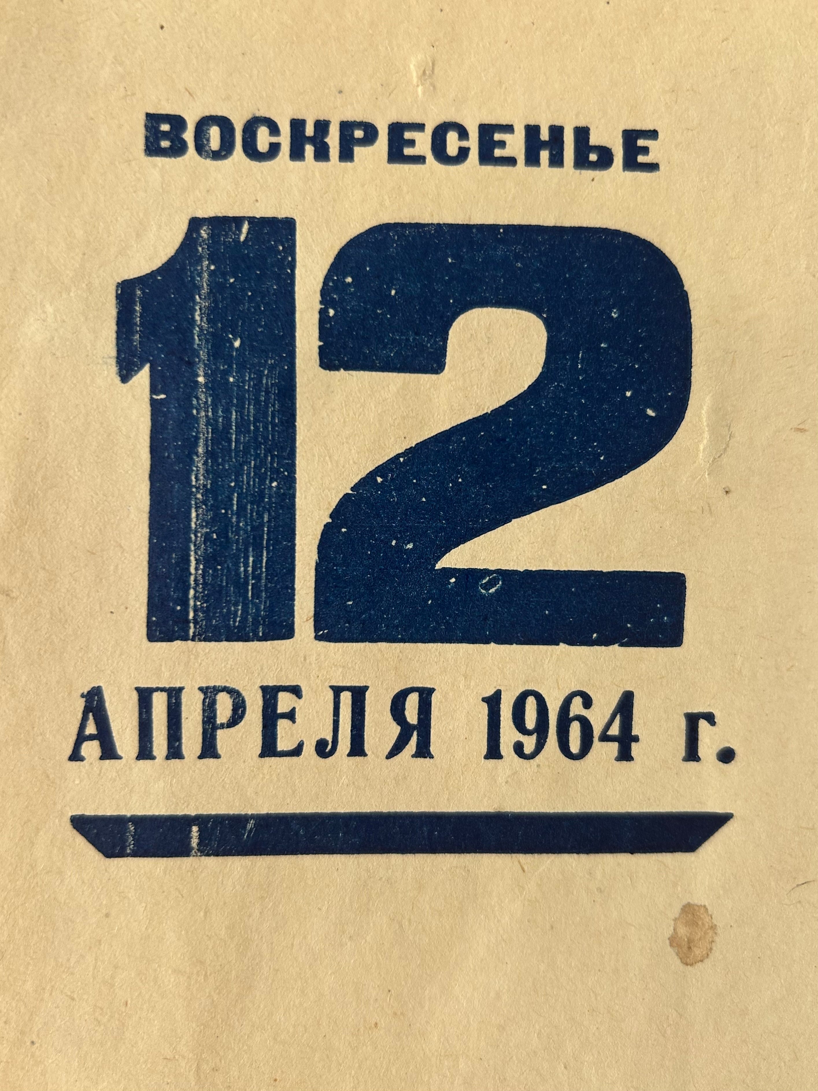 Vintage paper cover or print with Russian text reading 'ВОСКРЕСЕНЬЕ 12 АПРЕЛЯ 1964 г.' in dark blue on a warm beige background.