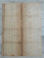 A vintage Russian paper poster or advertisement with faded text, laid flat on a light gray wooden surface.