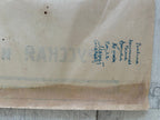 A close-up of a vintage, aged beige paper envelope or letterhead with blue handwritten address text on the right side and faint gray stamped text on the left.