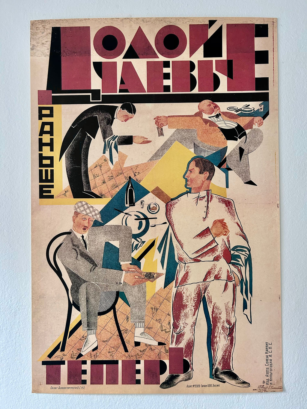 A vintage Russian art poster featuring stylized figures in geometric, expressionist composition with bold typography in Cyrillic, shown against a light wall.