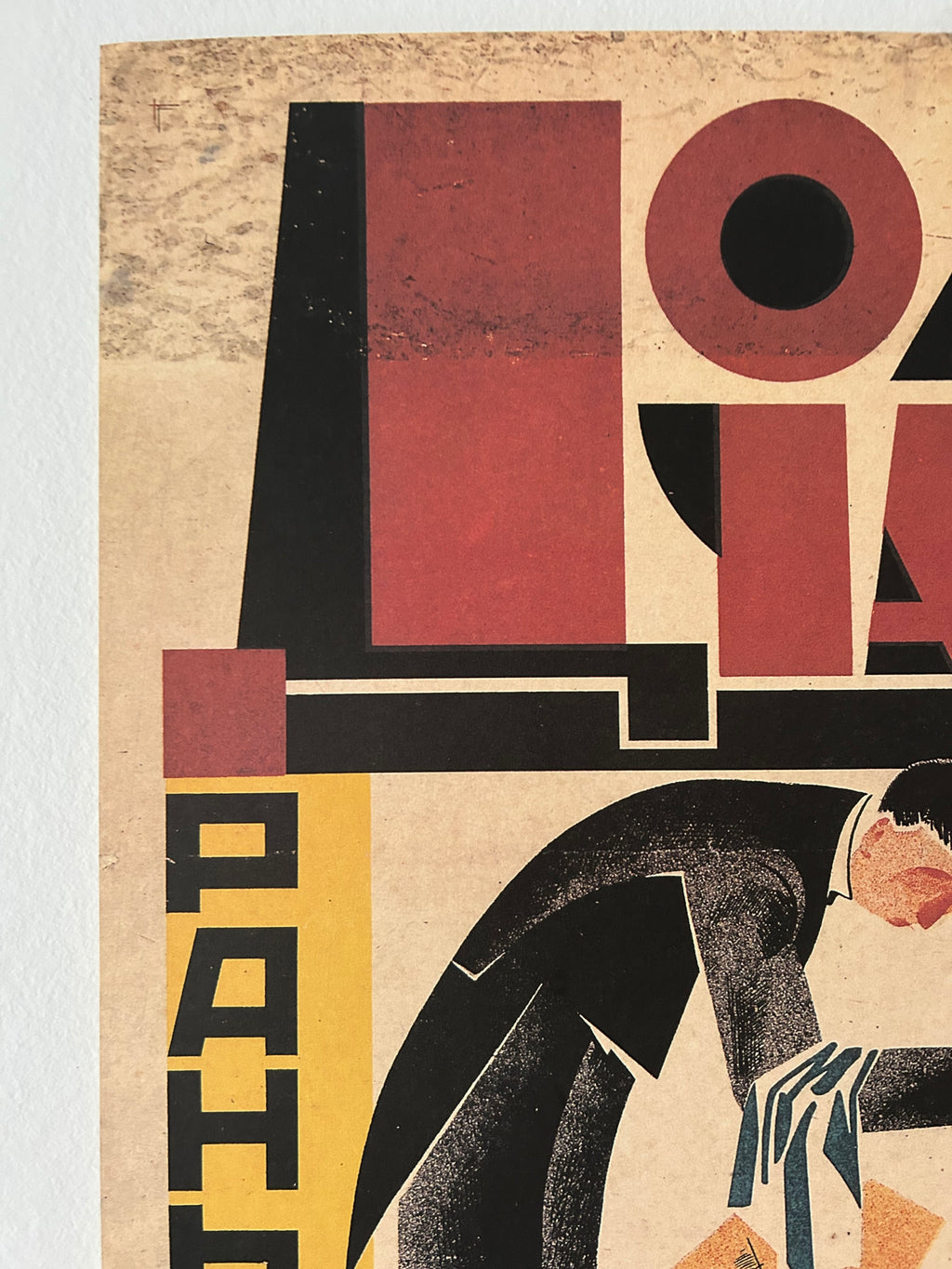 A close-up of a vintage-style poster or art print featuring abstract geometric shapes and a stylized figure in black, burgundy, cream, and yellow tones.