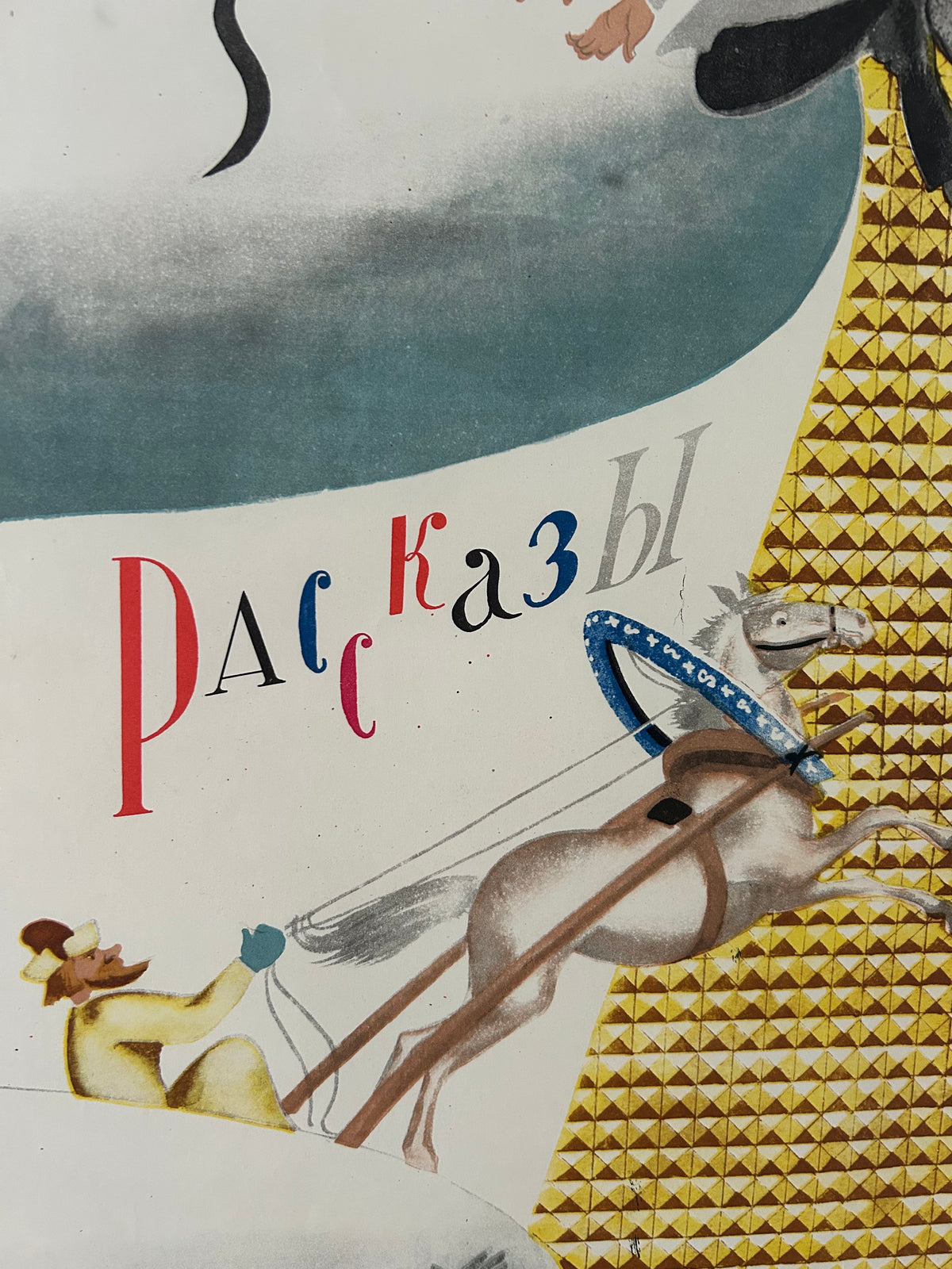 A close-up of a printed artwork or book/poster page showing a stylized horse with a blue bridle, a gold geometric patterned background, and vertical stylized text in red, blue, and black.