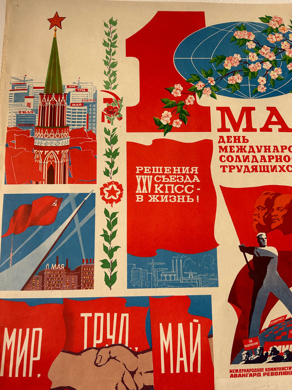 A vintage Soviet propaganda poster print featuring bold red, blue, green, and cream sections with Cyrillic text, a globe with flowers, a figure in a red coat, buildings, and a raised fist.
