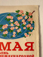 Vintage Russian propaganda poster print featuring a cherry blossom branch with pink flowers and green leaves over a blue oval background, with large red Cyrillic text on a cream-colored field.