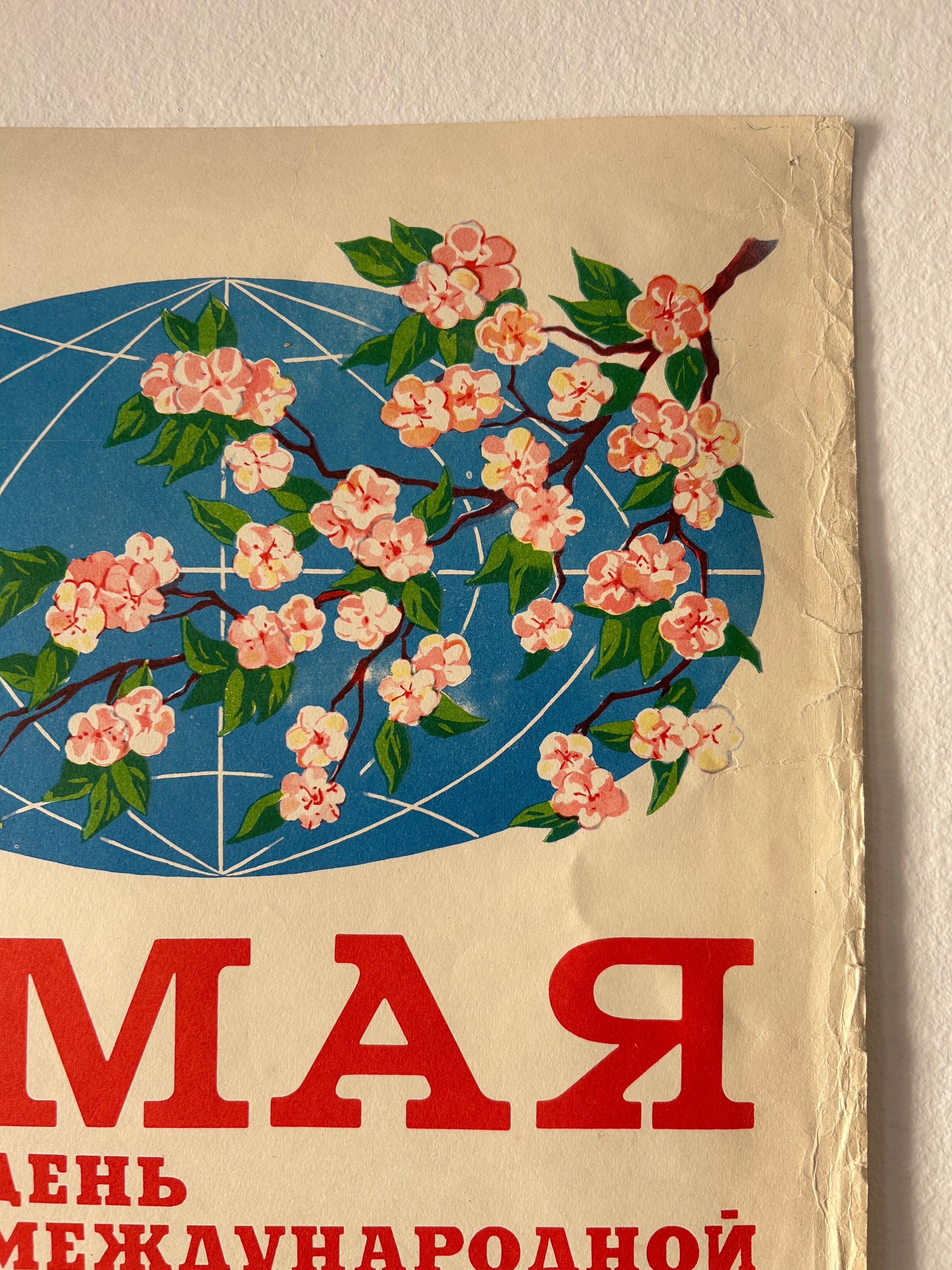 Vintage Russian propaganda poster print featuring a cherry blossom branch with pink flowers and green leaves over a blue oval background, with large red Cyrillic text on a cream-colored field.