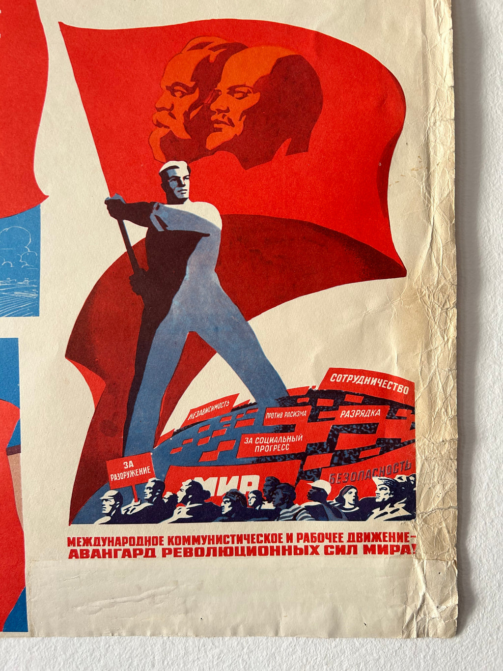 A vintage Soviet propaganda poster print featuring a stylized worker carrying a hammer and sickle against a large red flag, with Cyrillic text and a cream paper background.