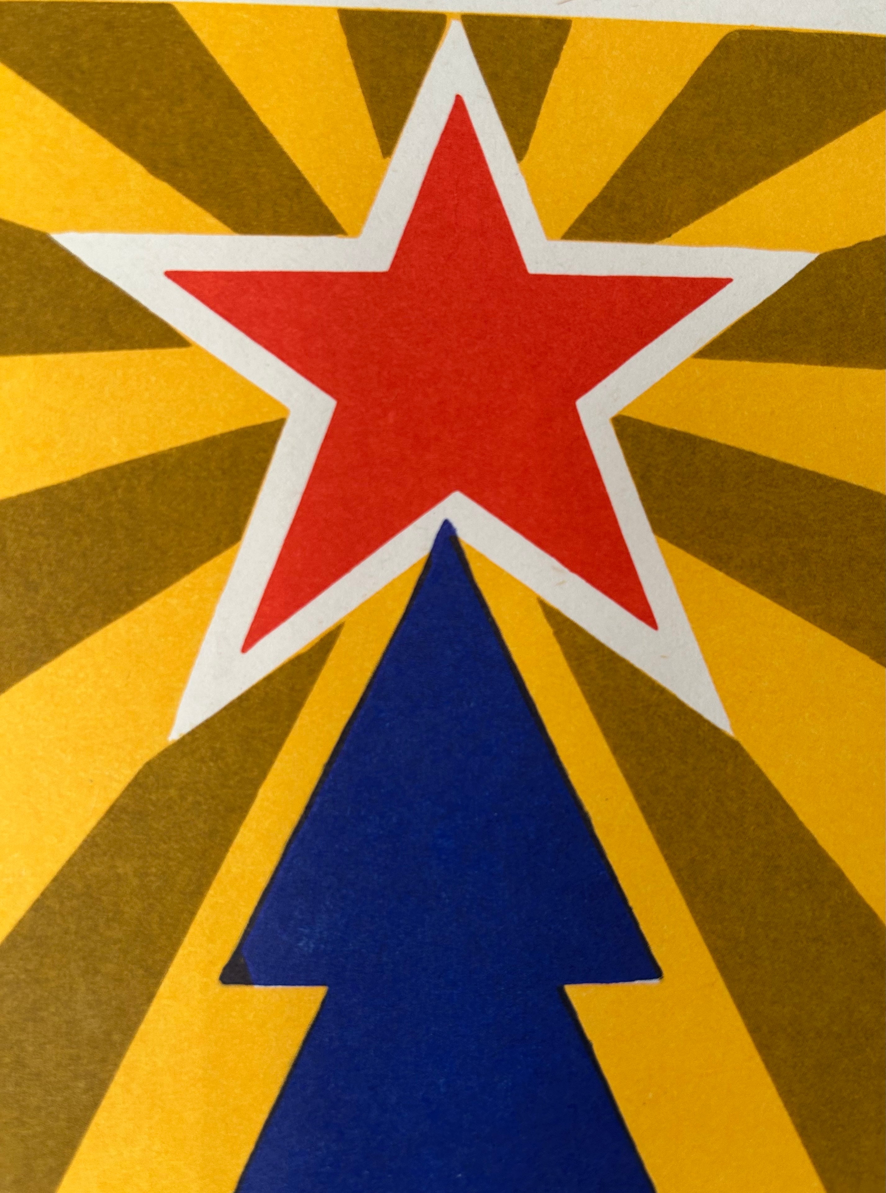 A close-up of a graphic design featuring a red five-pointed star outlined in white, set against a yellow and brown sunburst background with a blue upward-pointing triangle below.