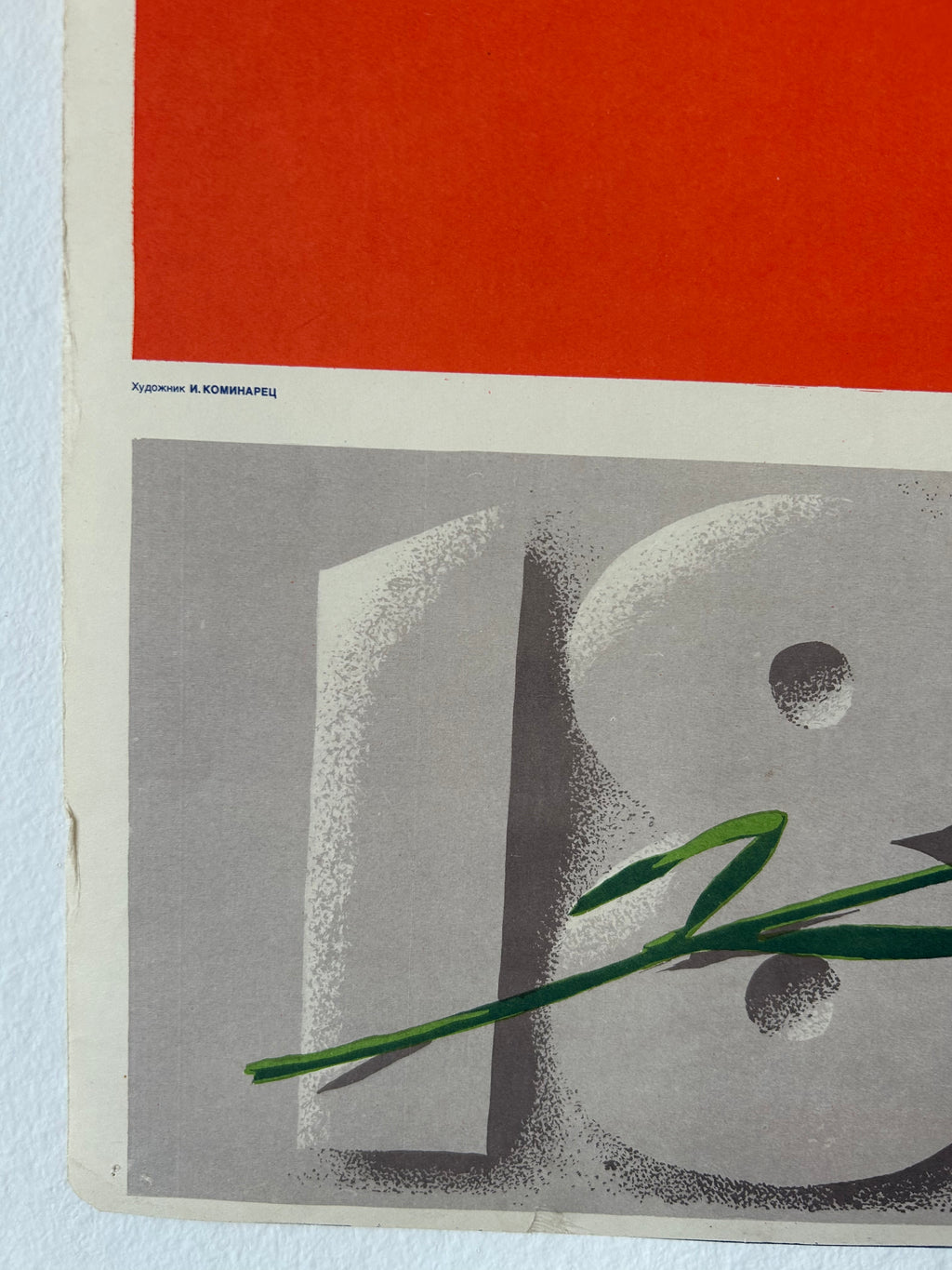 A close-up of a vintage-style poster or print featuring a large gray number 8 with a green leaf crossing it, below a solid orange-red block. Small printed text appears along the left edge.