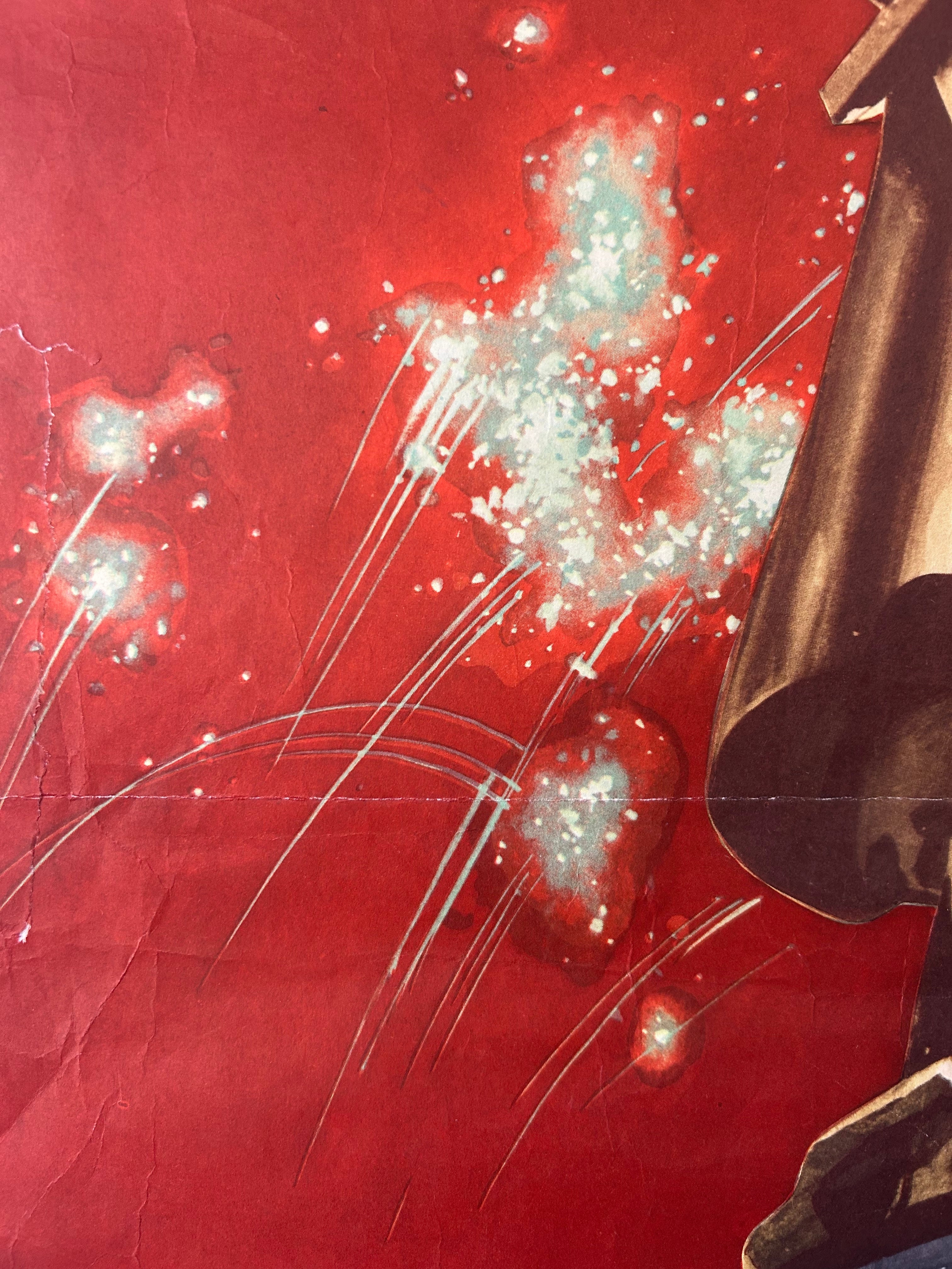 A close-up of a red printed surface with abstract white and pale blue splatter-like marks, streaks, and part of a dark brown or black object entering from the right edge.