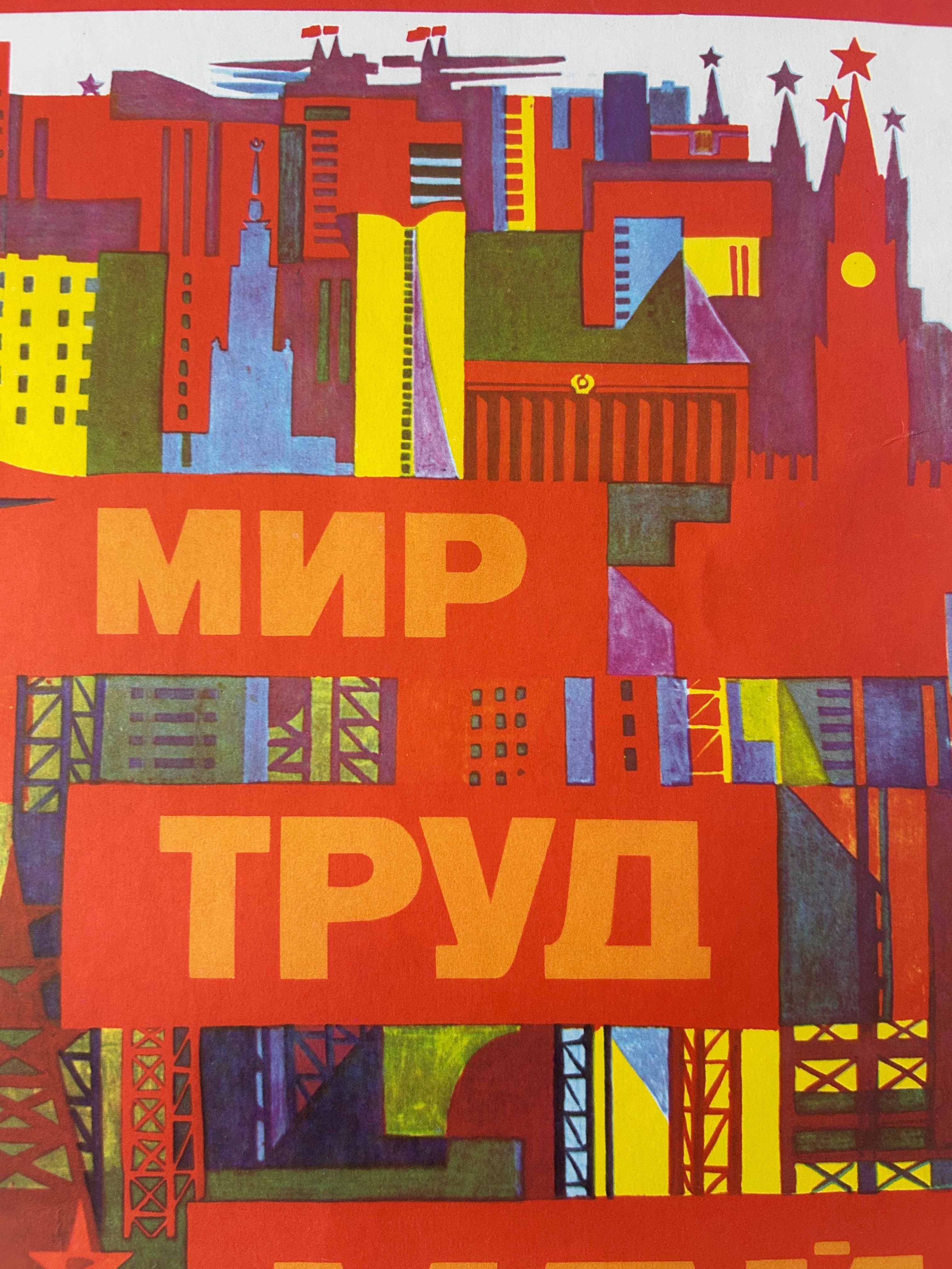 A colorful graphic poster featuring a stylized city skyline in red, orange, yellow, blue, green, and purple tones, with large Russian text reading “МИР ТРУД” across the center.