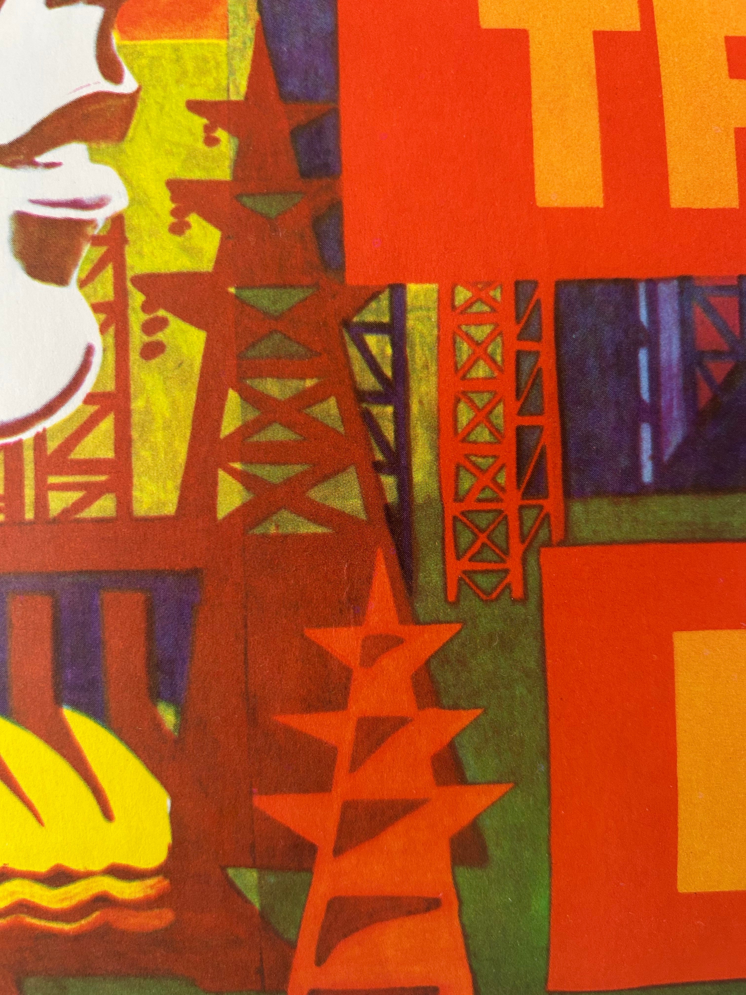 A close-up of a colorful graphic print or poster featuring stylized industrial structures, bold geometric shapes, and large letters in red, orange, yellow, green, and purple.