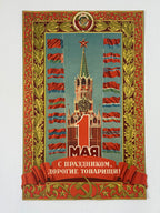A vintage Soviet-style poster print featuring the Spaso-Basilievskaya tower in Moscow, surrounded by red and blue flags, with a large red '1' and Cyrillic text at the bottom, bordered by ornate gold and red decorative frames.