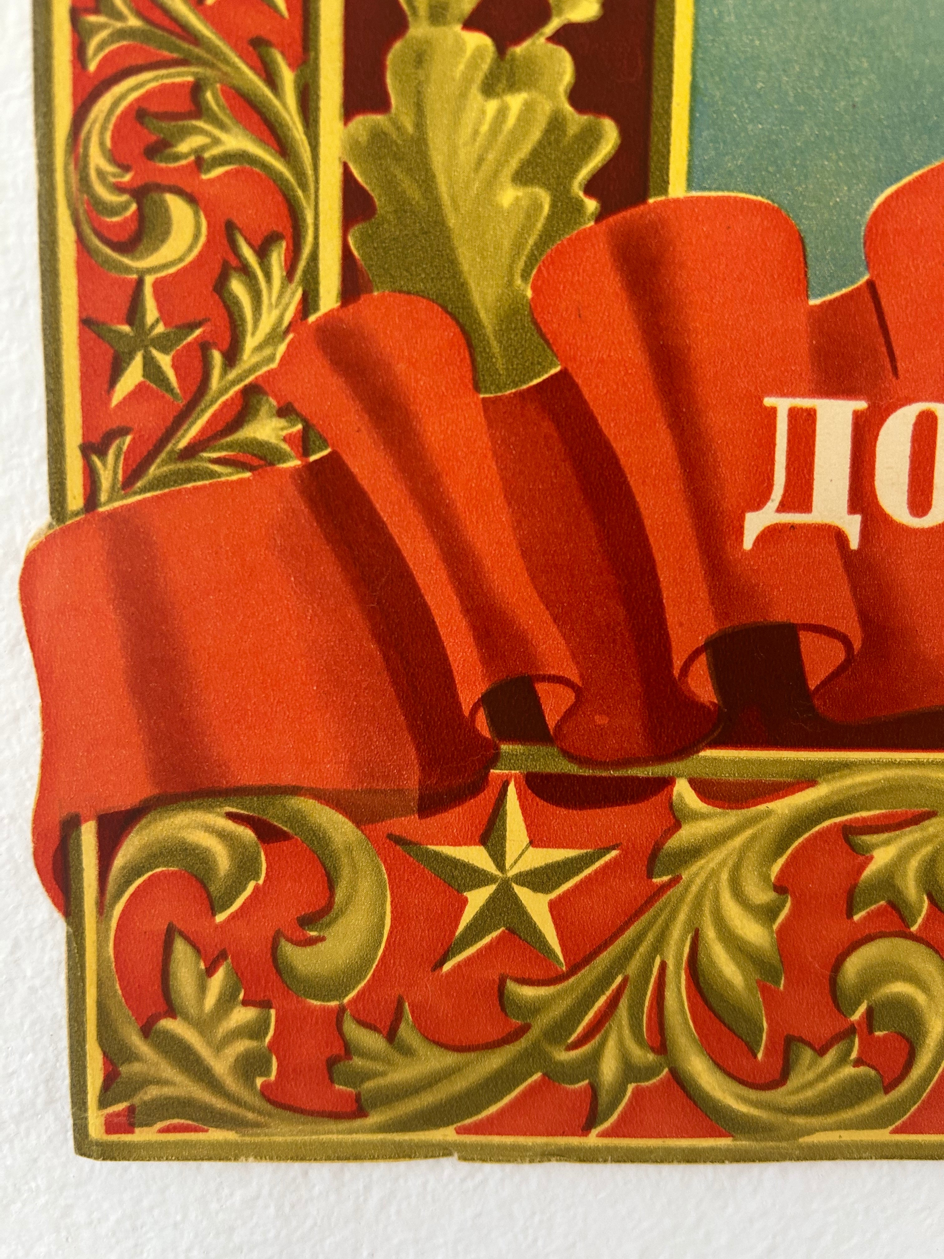 A close-up of a vintage-style decorative card or print featuring a large red ribbon bow, gold ornamental scrollwork, a gold star, and part of a teal background with white Cyrillic lettering.