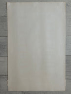 A blank, off-white textured paper sheet or card with slightly warm cream tones, laid flat on a gray wood plank background.
