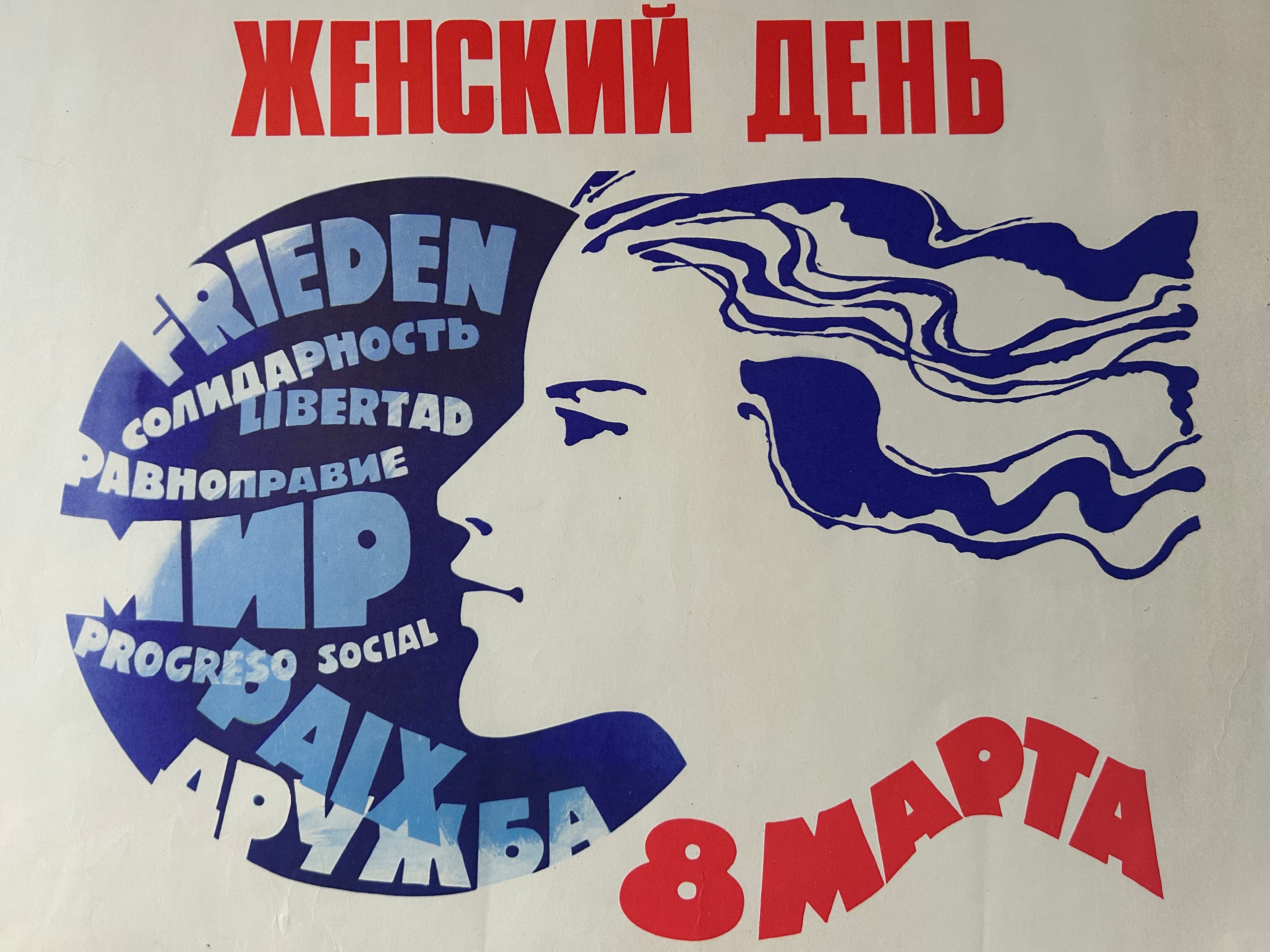 A vintage-style poster with Russian text in red and blue, featuring a stylized blue profile of a woman's face with flowing hair and a large circular text element reading 'FRIEDEN' with additional words inside. The bottom right shows '8 МАРТА' in red.