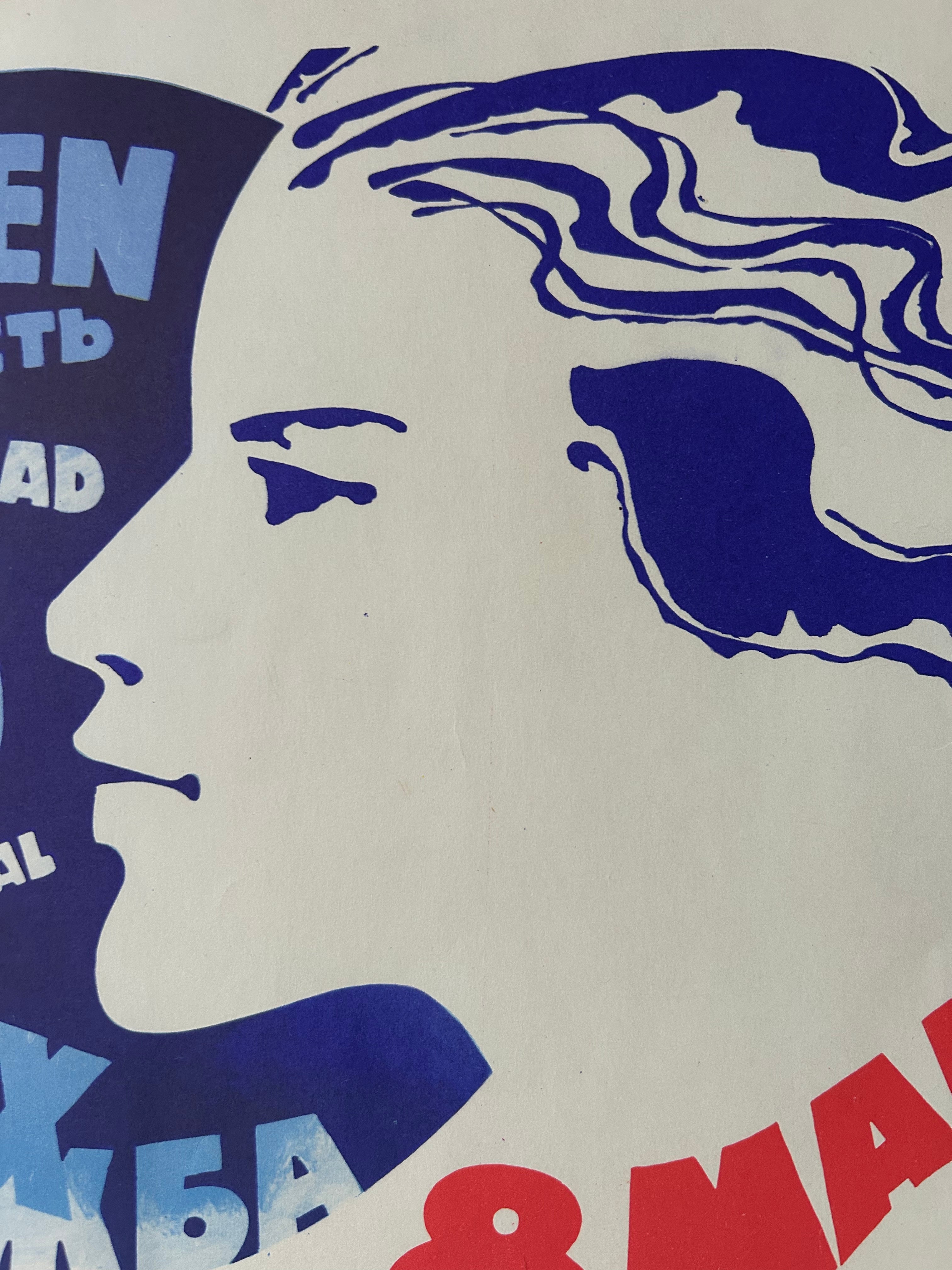 A close-up of a graphic print featuring a stylized profile of a woman's face in blue and white, with partial red and blue text on an off-white background.