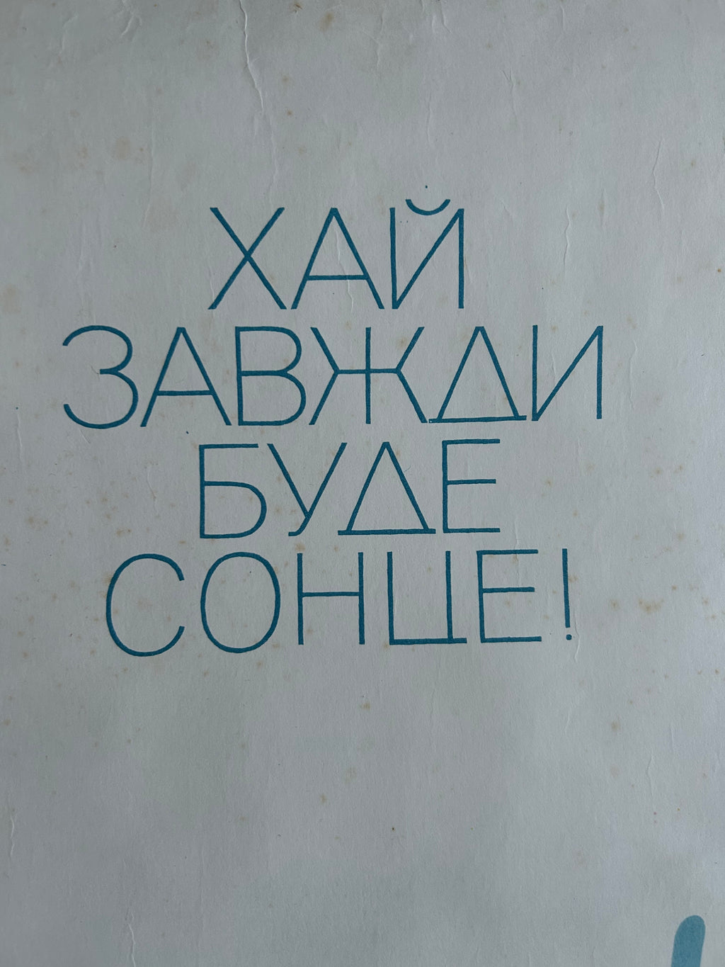 Blue Cyrillic text on a light gray textured background.