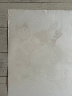 A square off-white art print or poster featuring a faint, low-contrast portrait sketch of a person in a baseball uniform, laid flat on a gray wood plank surface.